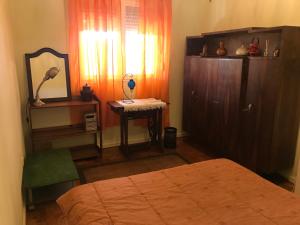 里斯本A casa do bairro的一间卧室配有床、梳妆台和台灯。