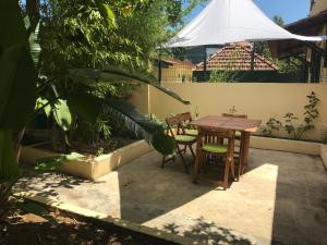 里斯本A casa do bairro的庭院配有桌椅和白色遮阳伞。