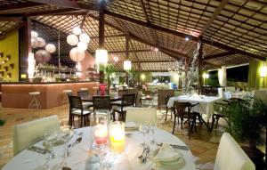 皮帕GIRASSÓIS - Suítes的一间设有白色桌椅的餐厅和一间酒吧