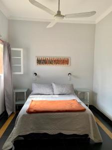 Curuzú CuatiáContinental Hotel的一间卧室配有一张带橙色毯子的床