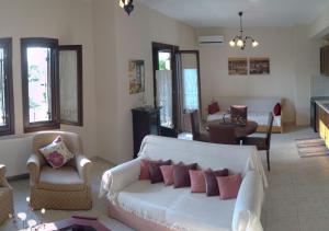 科罗皮Harmony seaside apartments的客厅配有白色的沙发和椅子