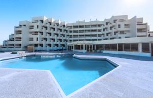 丹吉尔UMH Tarik Hotel的一座大型建筑,前面设有一个大型游泳池
