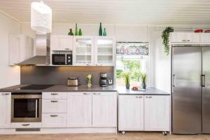 AlskatVilla Sjöman - with seaview的厨房配有白色橱柜和不锈钢冰箱