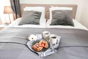 AlskatVilla Sjöman - with seaview的床上的早餐盘,包括甜甜圈和2杯