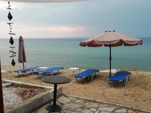 斯卡拉索提罗斯Marti Resort的海滩上的桌椅和遮阳伞
