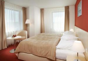 捷克布杰约维采捷克布杰约维采克拉丽奥酒店的酒店客房设有一张床、一张桌子和两个窗户。