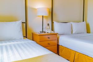 长滩岛皇冠丽晶王子度假村的酒店客房设有两张床和一部位于床头柜上的电话