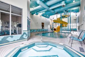 卡尔加里康福特茵南部酒店&套房的大楼内一个带滑梯的游泳池