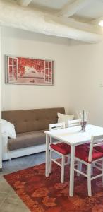 博尔塞纳La Casa di Alberto的带沙发的客房内的白色桌椅
