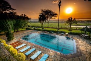 纳库鲁纳库鲁湖山林小屋的一个带躺椅的游泳池,享有日落美景
