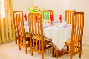 阿克拉Charis Home Services的餐桌、椅子和白色桌布