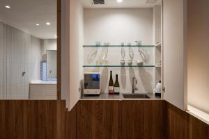 仓敷滔々 御崎 二階の宿 toutou Onzaki Nikai no Yado的厨房配有带葡萄酒瓶和水槽的吧台