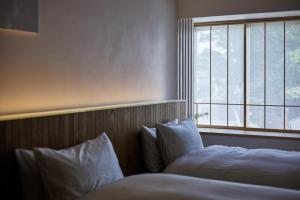 仓敷滔々 御崎 二階の宿 toutou Onzaki Nikai no Yado的一间卧室设有两张床和窗户。