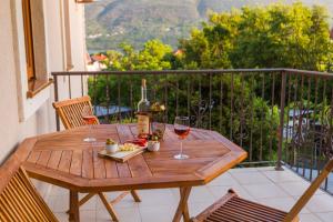 鲍希茨Perla di boka的阳台上的木桌和两杯葡萄酒