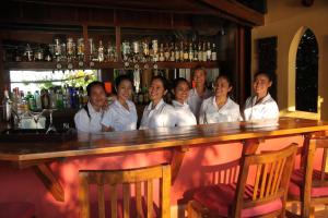 贡布Rikitikitavi的一群身穿白衬衫的女人站在酒吧后面