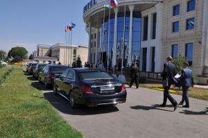 乌尔根奇Hotel Uzbekistan的一群人沿着汽车旁边的街道走着