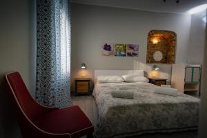 皮佐Villa Primaluce的一间卧室配有一张床和一张红色椅子