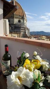 佛罗伦萨Santaelisabettafirenze1的一张桌子,上面放着一束鲜花和一瓶葡萄酒