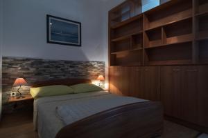 波斯蒂拉Apartments Ivana的一间卧室配有一张大床和木制橱柜。