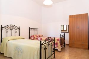 新福卡Villa Limoni 7 posti letto - San Foca的一间卧室配有两张单人床和一个梳妆台