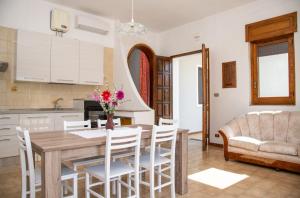 新福卡Villa Limoni 7 posti letto - San Foca的厨房以及带木桌和椅子的用餐室。