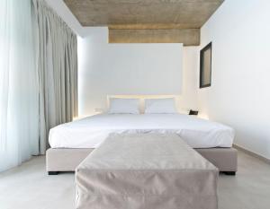 克拉默特The Oak Hotel的白色的卧室设有一张大床和白色的墙壁