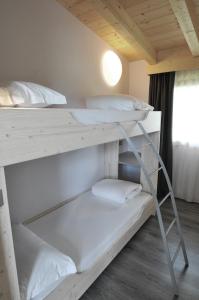 莫尔韦诺Bungalows Chalets Lago di Molveno的带窗户的客房内的两张双层床