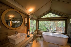 侯斯普瑞特Bundox Safari Lodge的带浴缸、水槽和镜子的浴室