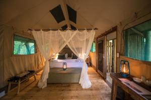 侯斯普瑞特Bundox Safari Lodge的一间卧室配有一张带天蓬的床