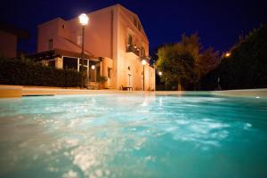 马泰拉莱多拉卡西诺酒店的一座游泳池,在晚上在建筑物前