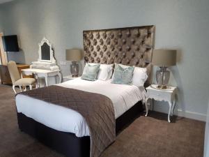 彼索普斯托福传统大哈林勃利庄园酒店的一间卧室配有一张大床和镜子