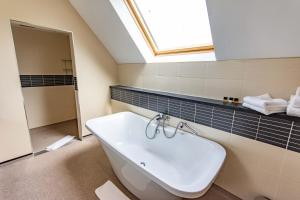彼索普斯托福传统大哈林勃利庄园酒店的浴室配有白色水槽和天窗。