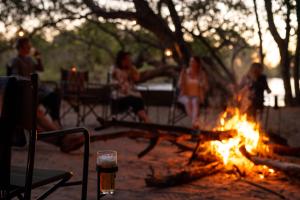 PungaIchingo Chobe River Lodge by Mantis的一群人围坐在火炉旁