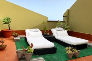 弗龙特拉Apartamentos Los Verodes的天井设有两张沙发和盆栽植物