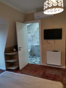 西格纳吉贝尔维尤精品酒店的一间卧室设有带浴缸的浴室和电视。