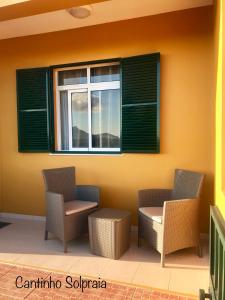 圣港Cantinho Solpraia的一个带两把椅子和窗户的庭院