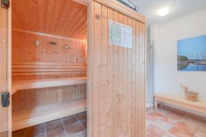 蒂索Strandhaus Thiessow Whg_ 3的一间设有木镶板和木墙的桑拿浴室