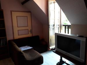 Marcillac-Saint-Quentinhalte aux places的一间带电视和沙发的客厅