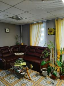 伊万诺沃Zubkovskiy Hotel的客厅配有真皮沙发和桌子