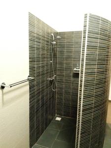 尼亚加乐卡劳杜拉客玫瑰酒店的浴室设有黑色瓷砖淋浴。