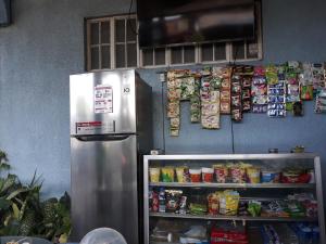 Dalumpinas Oestecv bed n bath san juan的食物架旁厨房里的冰箱