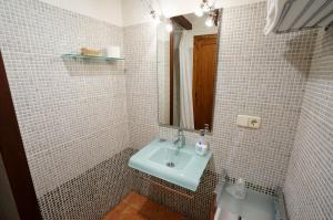 奥尔塔-德圣胡安Casa rural con mucho encanto en un entorno mágico的白色瓷砖浴室设有水槽和镜子