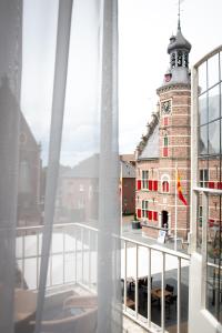 GennepHotel De Kroon Gennep的从带钟楼建筑的阳台欣赏风景