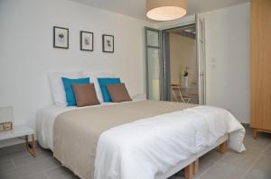 图卢兹克洛斯戴斯萨兰酒店的白色卧室配有一张带蓝色枕头的大床