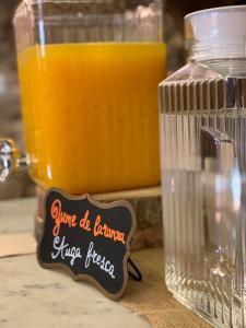 曼萨内达曼萨内达佩纳宫乡村民宿的一杯橙汁,旁边放着一罐橙汁