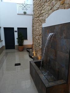 阿尔加尔Aljibe Casa Rural的石墙房间内的喷泉