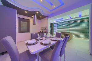 克尔克Luxury VALL Apartment的一间带桌子和紫色椅子的用餐室
