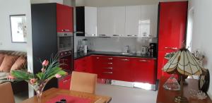 波卢巴库苏斯Casa Martin的厨房配有红色橱柜和带台灯的桌子