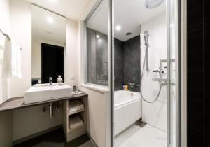 姬路Daiwa Roynet Hotel Himeji的白色的浴室设有水槽和淋浴。