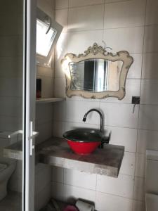 格里戈莱蒂Mana-Mana的一间带红色水槽和镜子的浴室